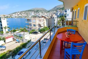 a balcony with a table and chairs and a view of the water at Vila Lida in Sarandë