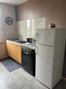 a kitchen with a white refrigerator and a sink at APPARTEMENT 4 PERSONNES CLASSE 2 ETOILES LEBOUCQ Laurent in Fort-Mahon-Plage