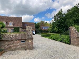un muro di mattoni con un cancello di fronte a una casa di Rustig appartement in het groen met terras a Kontich