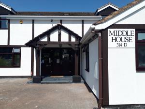 une porte menant à une maison intermédiaire avec un panneau. dans l'établissement Middle House, à Coventry