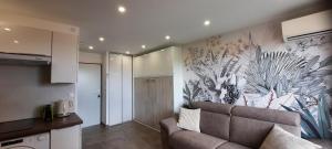 sala de estar con sofá y mural en la pared en Charmant Studio Sète cosy Refait à neuf Parking Plage à pied, en Sète
