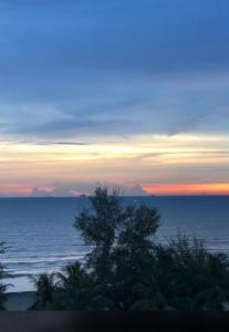 a view of the ocean at sunset at Beach view apartment from balcony in Banting