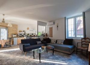 ein Wohnzimmer mit einem Sofa und einem Tisch in der Unterkunft Au Pont Vert in Fontaine-Française