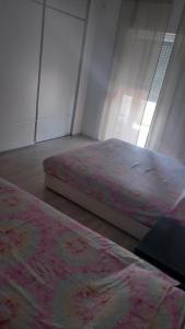 two beds sitting in a room with a window at Septemvri 7 in Kavadarci +12 photos