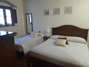 a hotel room with two beds and two lamps at Poggio Desto Bed & Breakfast in Quarrata