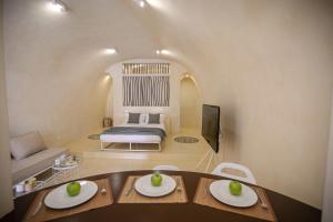 a room with a bed and a table with plates on it at Azalea Houses Cave Villa in Oia +18 photos