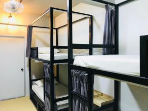 a room with a black bunk bed in a room at The Good Travelers Hostel - KL Airport in Sepang