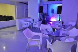 Pokój z białymi stołami i białymi krzesłami w obiekcie Hostal Lleras Calle 8 w mieście Medellín