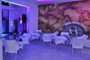 restauracja ze stołami i białymi krzesłami oraz mapą na ścianie w obiekcie Hostal Lleras Calle 8 w mieście Medellín