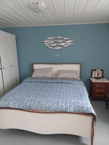 a bedroom with a bed with a blue wall at Hermes Penthouse in Ermoupoli