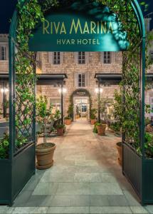 an entrance to a hotel with potted plants at Riva Marina Hvar Hotel in Hvar