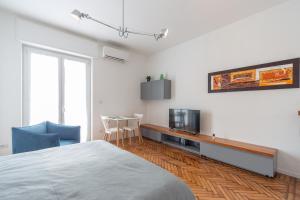 una camera da letto con un letto, un tavolo e una TV di Appartamento Ripa Milano a Milano