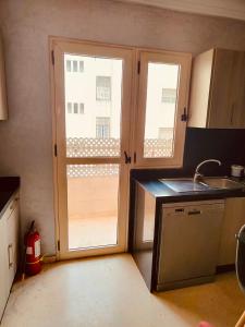 luxury apartments في الدار البيضاء: مطبخ فيه مغسلة ونوافذ
