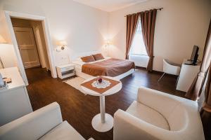 a hotel room with a bed and a table and chairs at Villa Istenič in Bizeljsko