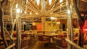 a restaurant with tables and chairs and a large ceiling at Roka Resort in Berakit