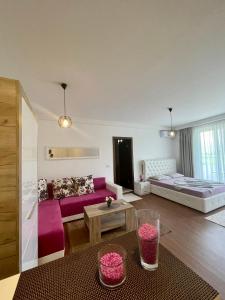 a living room with a purple couch and a bed at Casa Nita in Ulcinj