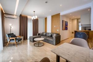 G Star Hotel في سوتوموري: غرفة معيشة مع أريكة وطاولة
