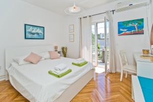 een witte slaapkamer met een bed en een bureau bij Villa ToTa Glamur in Jelsa