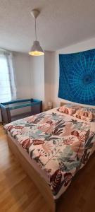 a bedroom with a bed with a colorful comforter at Duplex F3 hypercentre Cherbourg près du port in Cherbourg en Cotentin