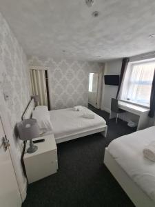 Postel nebo postele na pokoji v ubytování Queens Plaza Hotel
