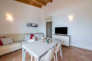 a living room with a white table and a couch at Il Gelsomino in Manerba del Garda