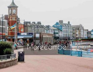 a city with a clock tower and a clock at Lovely 2 bedroom modern loft apartment sea view in Morecambe