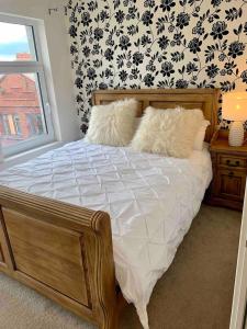 a bed with white sheets and pillows in a bedroom at Lovely 2 bedroom modern loft apartment sea view in Morecambe
