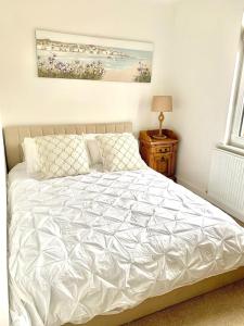ein Bett mit einer weißen Bettdecke in einem Schlafzimmer in der Unterkunft Lovely 2 bedroom modern loft apartment sea view in Morecambe