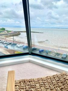 a window with a view of the beach and the ocean at Lovely 2 bedroom modern loft apartment sea view in Morecambe