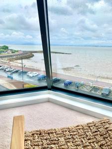 a window with a view of the beach and the ocean at Lovely 2 bedroom modern loft apartment sea view in Morecambe +5 photos