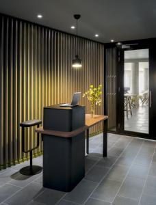 an office with a desk with a laptop on it at Okko Hotels Grenoble Jardin Hoche in Grenoble