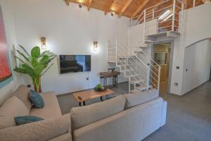 a living room with a couch and a staircase at Villa Garifalia with Sauna & Hydromassage in Chania
