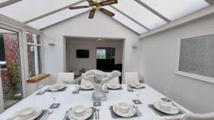 a dining room with a white table with a vase on it at Rozelle Villa in Ayr