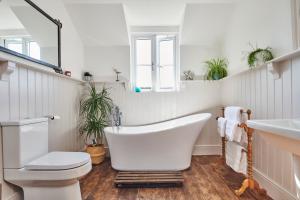 a bathroom with a tub and a toilet and a sink at Luxurious property set in the heart of Cornwall with breathtaking views -Rhubarb Cottage in Helston +41 photos