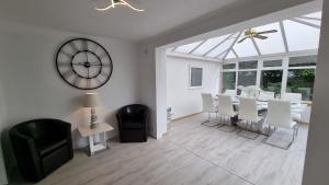 a dining room with a clock and a table and chairs at Rozelle Villa in Ayr