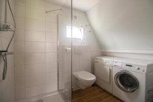 uma casa de banho com um WC e uma máquina de lavar roupa em Hermans huisje: het mooiste uitzicht van Twente? em Haaksbergen