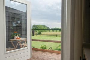 drzwi na balkon z widokiem na pole w obiekcie Hermans huisje: het mooiste uitzicht van Twente? w mieście Haaksbergen