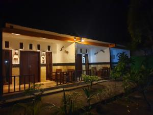 a building with tables and chairs at night at Five Time Homestay in Gili Islands