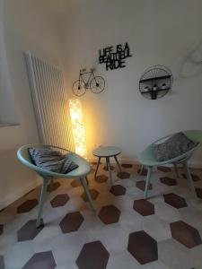 Pokój z dwoma krzesłami i stołami oraz rowerem na ścianie w obiekcie B&B Villino Luschi Pisa Centro w Pizie