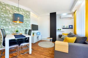 a living room with a couch and a table with a desk at Apartament 14 in Zwierzyniec