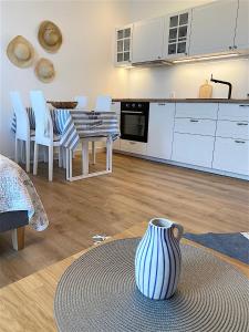 una cucina con tavolo, sedie e vaso di Apartamenty Marea Rentals Aquarius Ustka a Ustka
