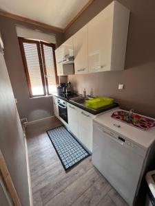 a small kitchen with white cabinets and a sink at APPARTEMENT 6 PERSONNES CLASSE 2 ETOILES LEBOUCQ Laurent in Fort-Mahon-Plage +9 photos