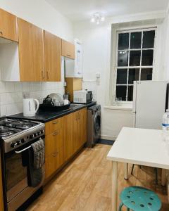 a kitchen with a stove and a refrigerator at HISTORIC ROYAL MILE FLAT , 5min FROM WAVERLY RAILWAY STATION in Edinburgh
