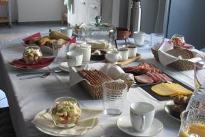 a table with a white table cloth with food on it at At Home in Dochamps