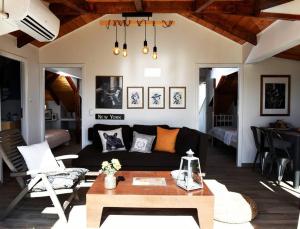 sala de estar con sofá negro y mesa en Countryside Loft - Inachos 