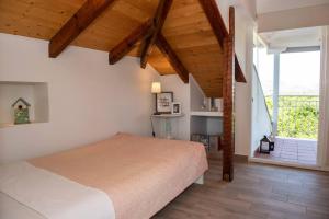 a bedroom with a large bed and a balcony at Countryside Loft - Inachos in Pasás