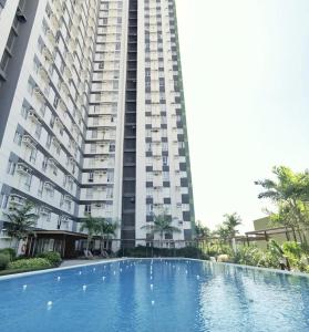 - un grand bâtiment avec une grande piscine en face dans l'établissement Topaz 1 Bedroom Suite Orochi Staycation PH at Centrio Towers, à Cagayán de Oro