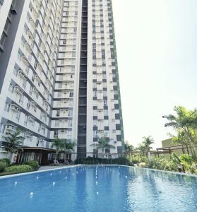 a large building with a large swimming pool in front of it at Topaz 1 Bedroom Suite Orochi Staycation PH at Centrio Towers in Cagayan de Oro