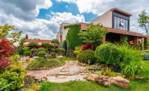 a garden in front of a house at Giuaani Winery in Manavi