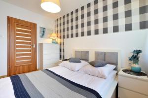 a bedroom with a large white bed with blue pillows at Apartament 14 in Zwierzyniec